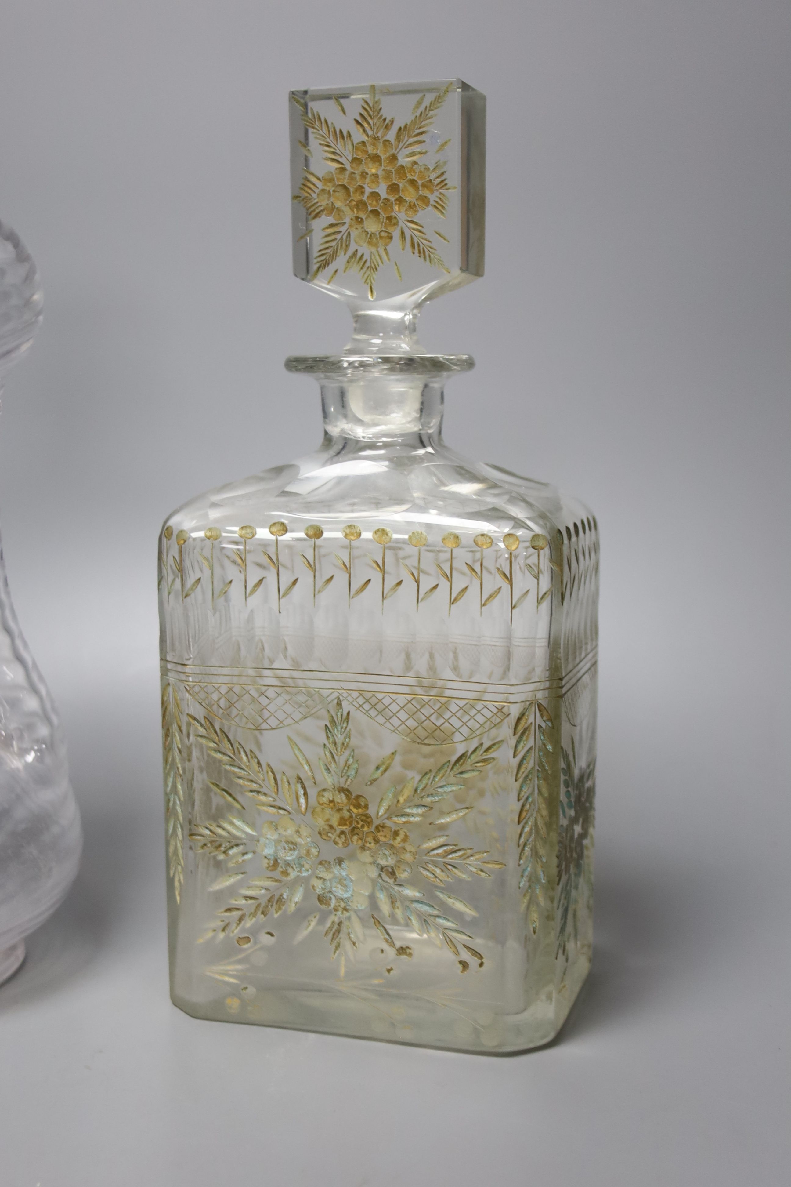 A Victorian wrythen moulded hour glass shaped decanter, with silver collar, 31cm high, togoether with a further 19th century engraved glass decanter (a.f.), 25cm high